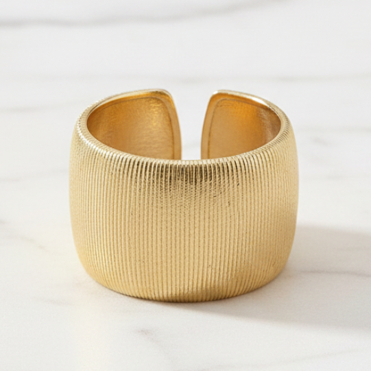 Gold ring on a white marble surface