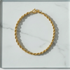 Gold chain bracelet on a marble surface