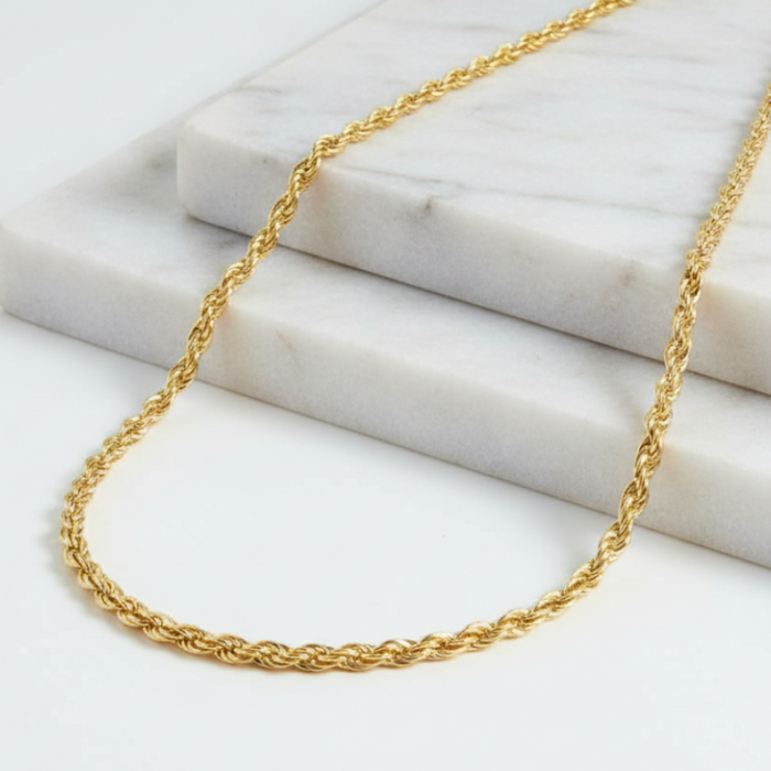 Gold chain necklace on a marble surface