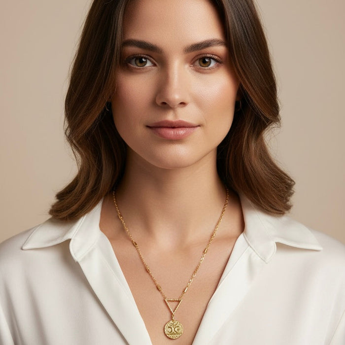 Woman wearing a gold necklace against a beige background