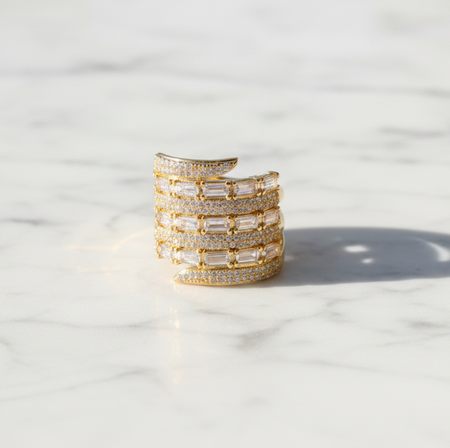Gold and crystal ring on a marble surface