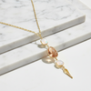 Gold necklace with opal and peach-colored stones on a marble surface
