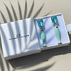 Pair of fish-shaped earrings with blue gemstones in a 'The Christy F Collection' box.