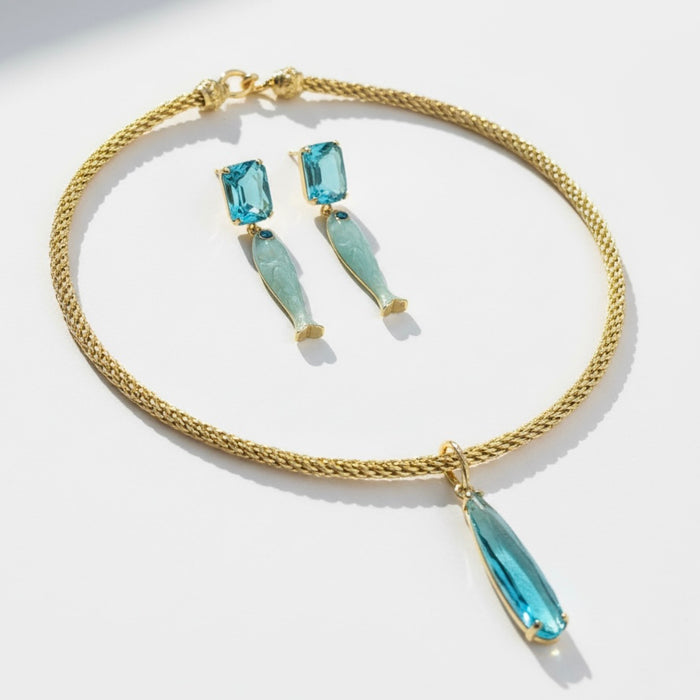 Gold necklace with blue teardrop pendants on a white background