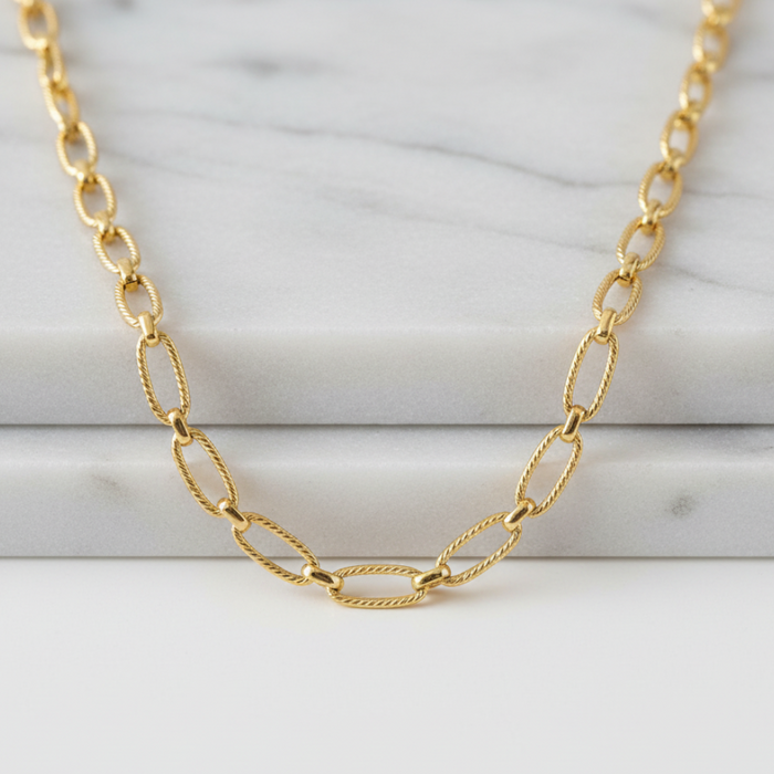 Gold chain necklace on a marble surface