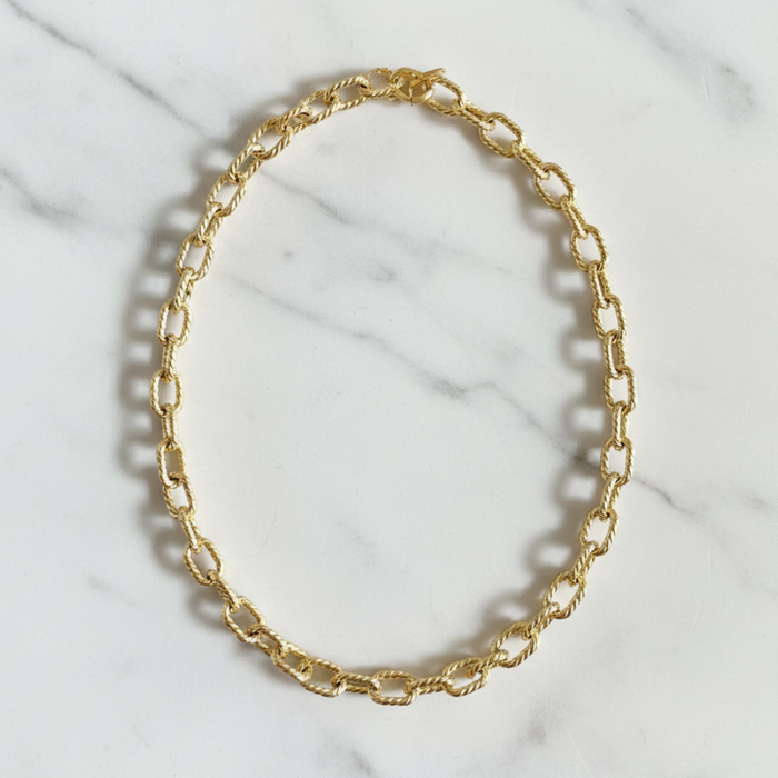 Gold chain necklace on a marble surface