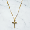 Gold cross necklace on a marble background