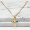 Gold cross necklace on a marble surface