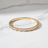 Gold ring with baguette diamonds on a white marble surface