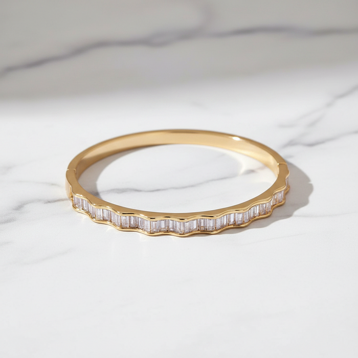 Gold ring with baguette diamonds on a white marble surface