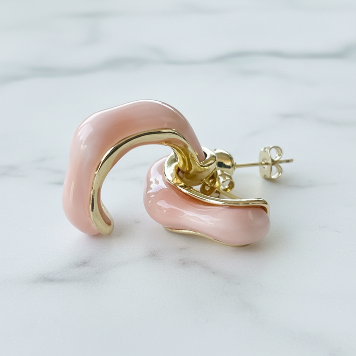 Pink and gold earring on a marble background