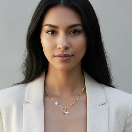 Woman wearing a white blazer over a sheer top with a gray background