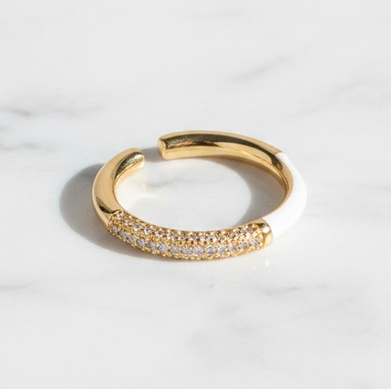 Gold open ring with embedded stones on a light background