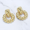 Gold hoop earrings on a marble surface