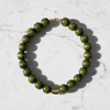 Green beaded necklace on a marble surface