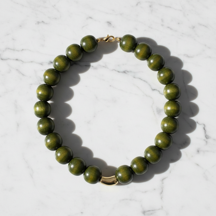 Green beaded necklace on a marble surface