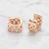 gold hoop earrings with x pattern on a light gray background