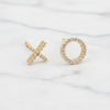 Gold earrings shaped like 'X' and 'O' on a white background