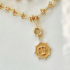 A gold-filled necklace with a zodiac pendant featuring a circular chain link design and a gold-tone pendant.