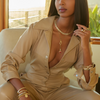 Woman in beige outfit sitting on a chair with a scenic background