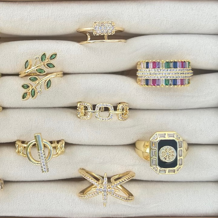 Collection of rings displayed on a wooden stand with a neutral background