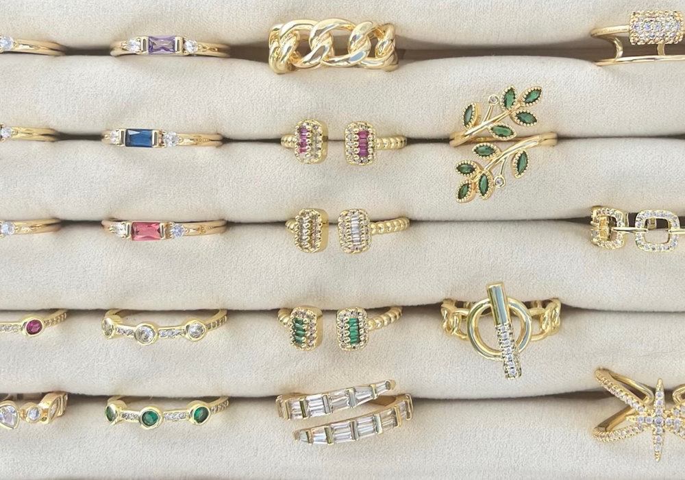 Collection of gold and gemstone rings on a white surface