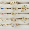 Collection of gold and gemstone rings on a white surface