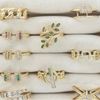 Collection of gold rings with various designs and gemstones on a white surface