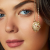 A gold-filled necklace with a pendant featuring a lioness design with bold ruby gemstone eyes, worn by a woman.