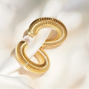 Gold hoop earrings on a white fabric background